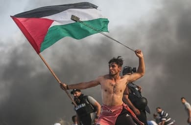 GAZA CITY, GAZA - OCTOBER 22: Palestinians throw stones and burn tyres in response to Israeli forces' intervention as they gather to support the maritime demonstration to break the Gaza blockade by sea with vessels in Gaza City, Gaza on October 22, 2018. (Photo by Mustafa Hassona/Anadolu Agency/Getty Images)